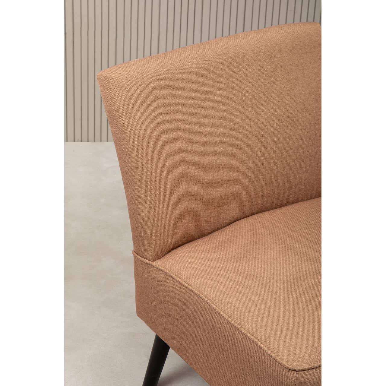 Closeup of tan fabric accent chair with black legs against a neutral background