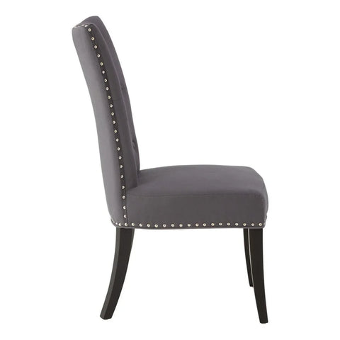 Grey upholstered dining chair with silver stud trim and black wooden legs side view