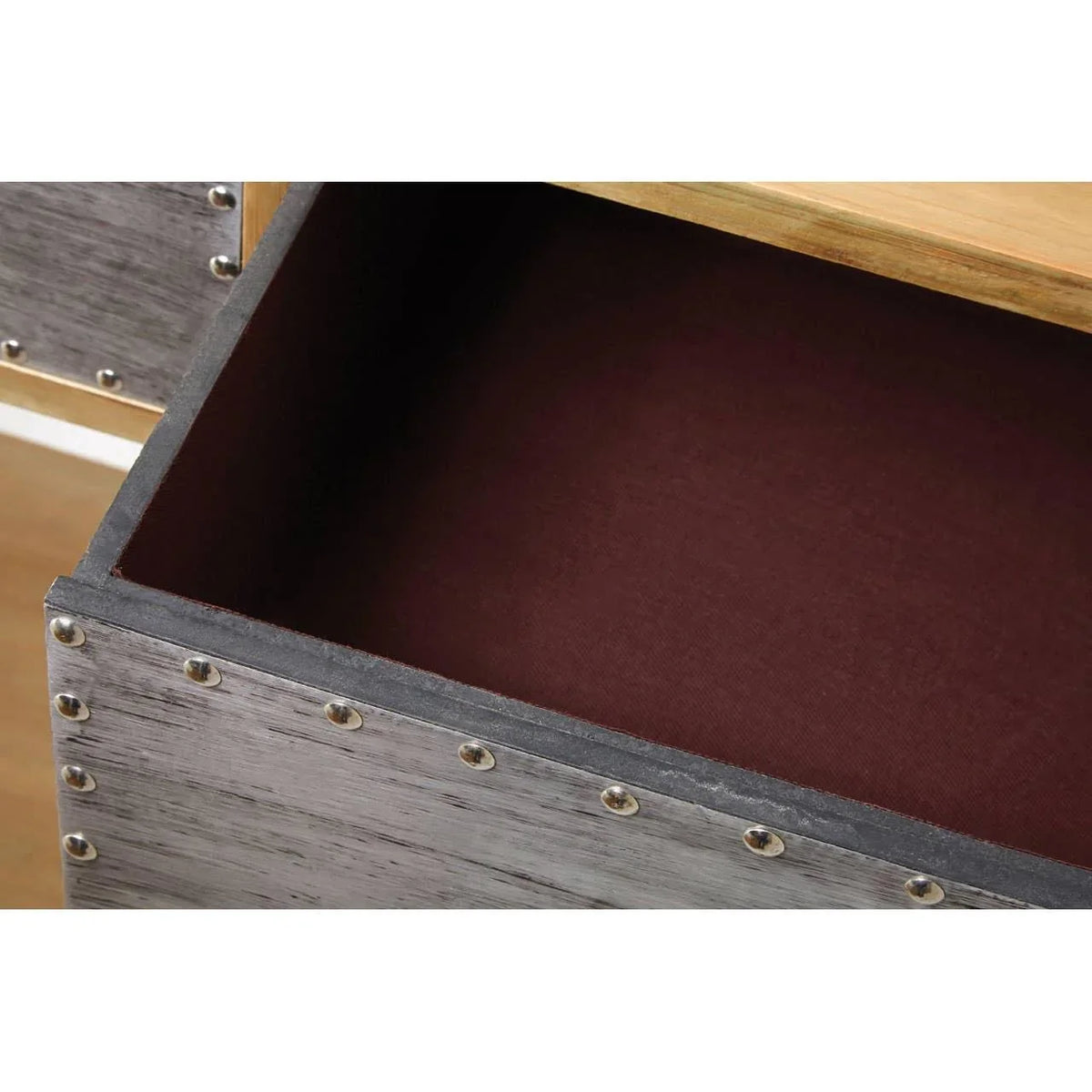 Close-up of wooden furniture drawer with metal rivet trim and dark interior