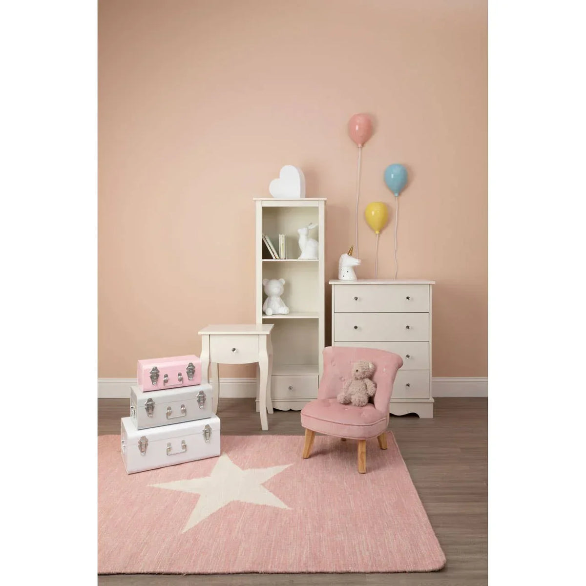Kids bedroom furniture set with white chest of drawers, shelf, side table and pink chair on star rug