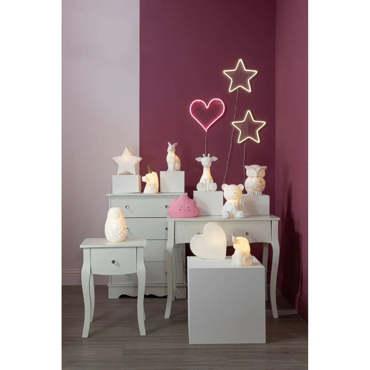 Children’s bedroom lamps and LED wall lights on white nightstands against purple walls