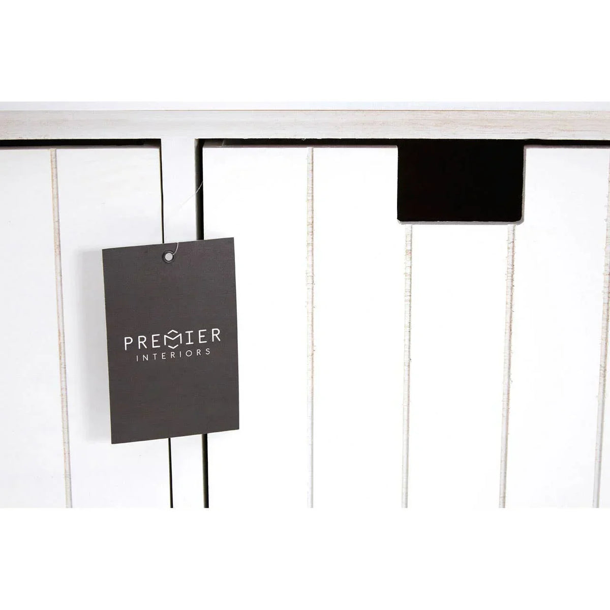 Closeup of white wooden furniture panel with vertical grooves and black Premier Interiors tag