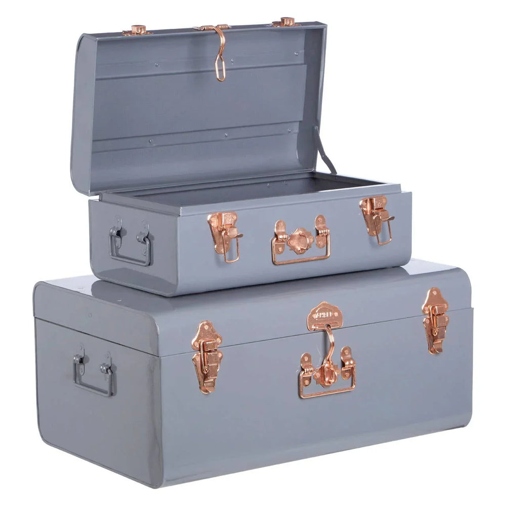 Set of two grey metal storage trunks with rose gold latches, one open, one closed