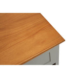The top surface of a cabinet featuring a smooth, warm-toned wooden finish, with a slight overhang at the edges. The cabinet has a light gray body and is designed to hold two drawers and four woven baskets for storage
