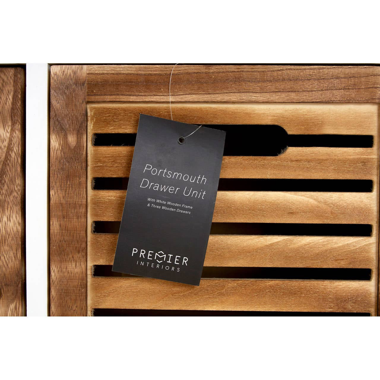 Natural wood drawer chest featuring slatted design on the front, with a black tag attached that displays the product name and details. The wood has a warm, rich finish, highlighting its natural grain