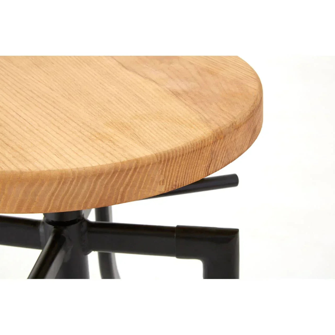 Close up of round wooden table top with black metal base