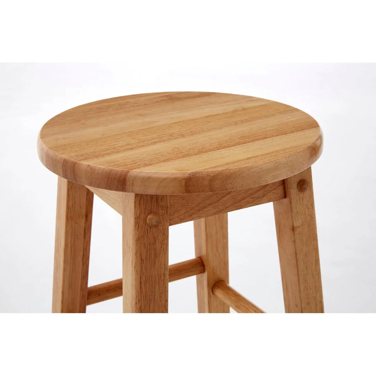 Round wooden stool with natural finish and four sturdy legs, close-up view