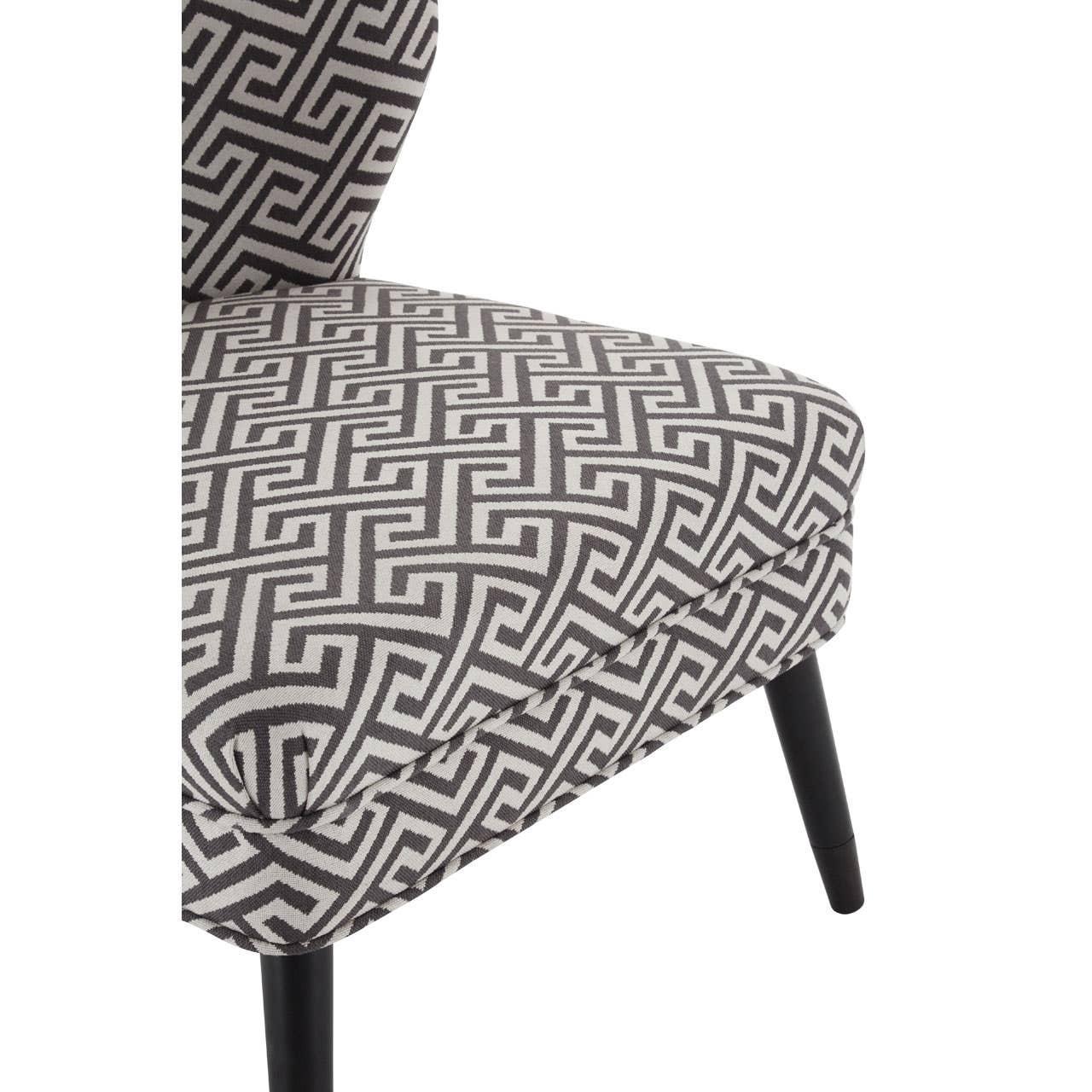 Grey patterned accent chair with Greek key fabric and black tapered legs close-up