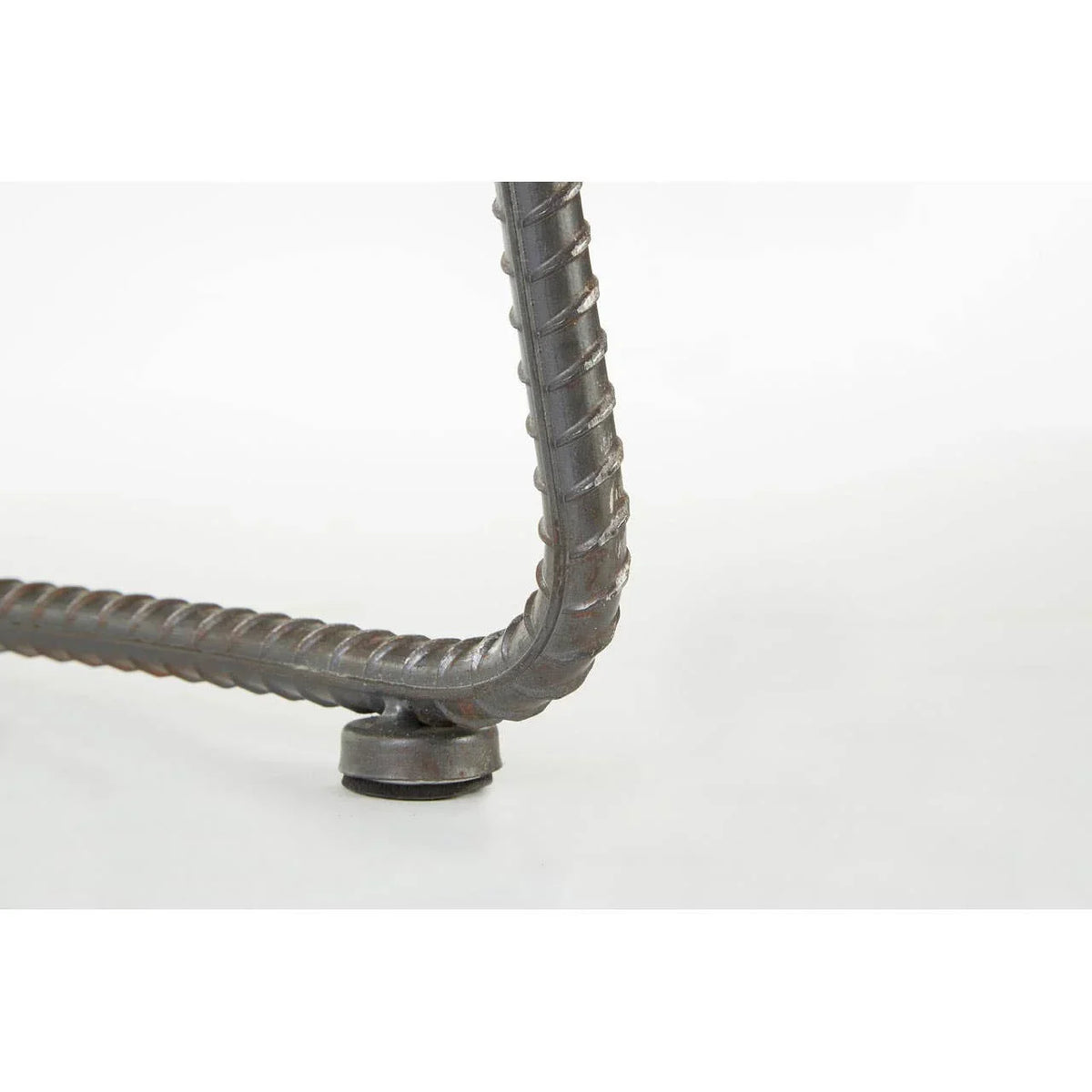 Close view of metal table leg with ribbed steel detail and adjustable foot