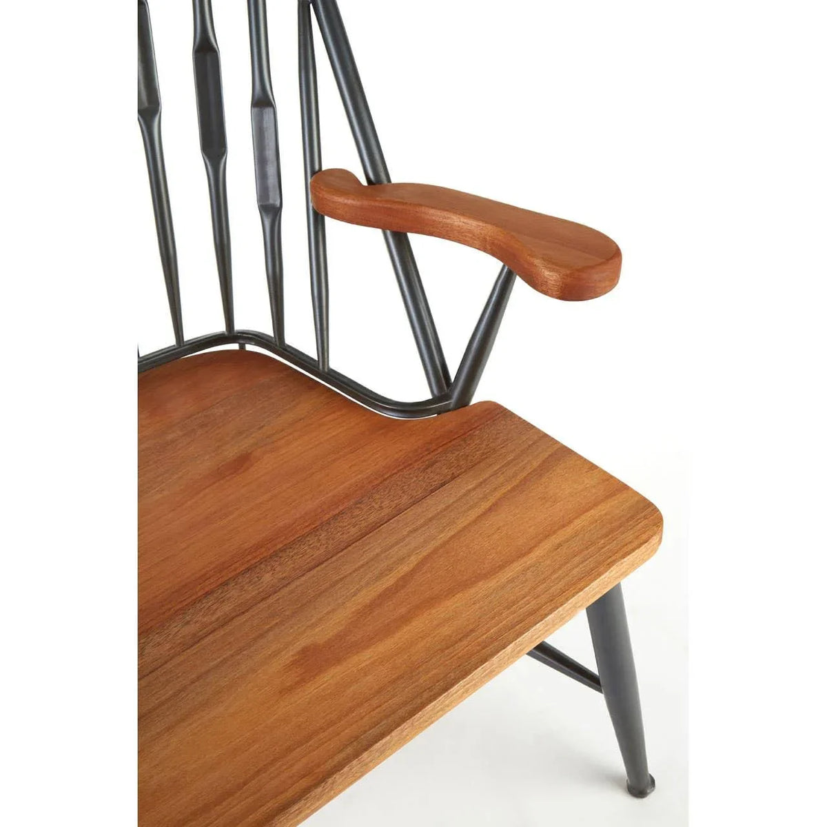 Close-up of wooden chair seat and armrest with black metal spindle backrest