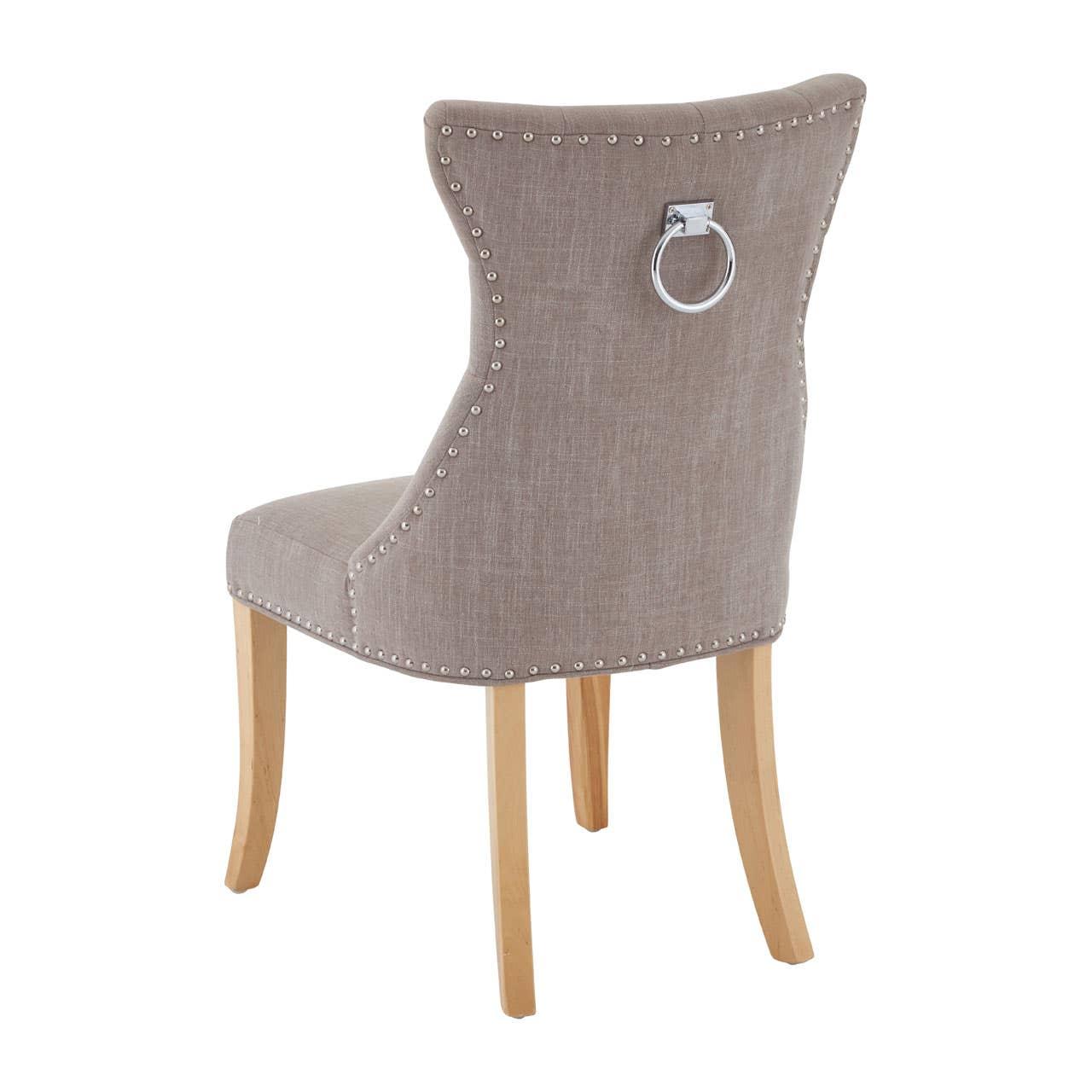 Taupe fabric dining chair with ring handle, stud trim, and light wooden legs, rear view