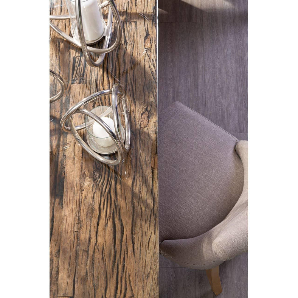 Textured wood dining table with glass decor beside taupe fabric dining chair
