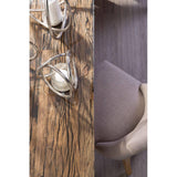 Textured wood dining table with glass decor beside taupe fabric dining chair