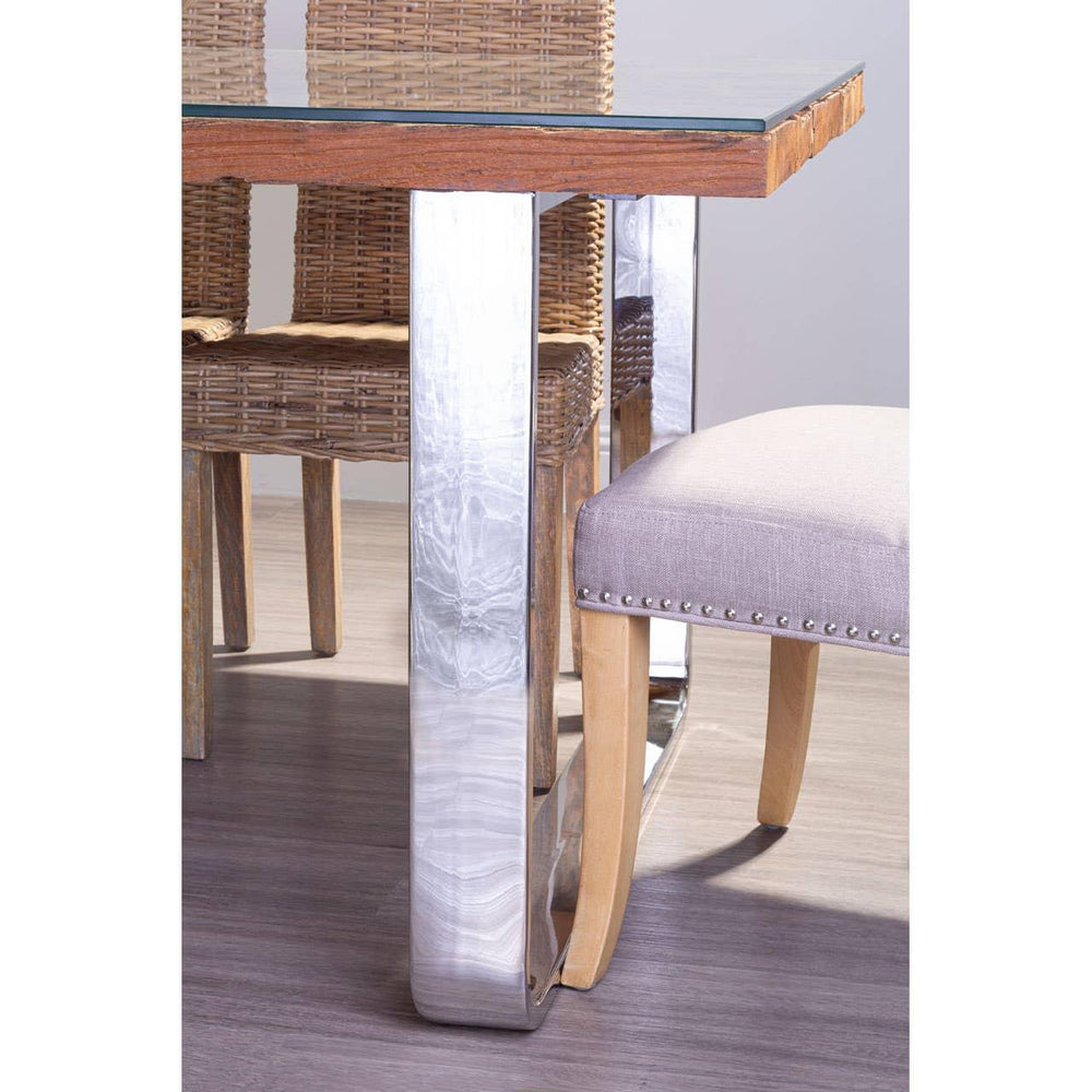 Glass top dining table with chrome legs and wicker chairs on wood floor
