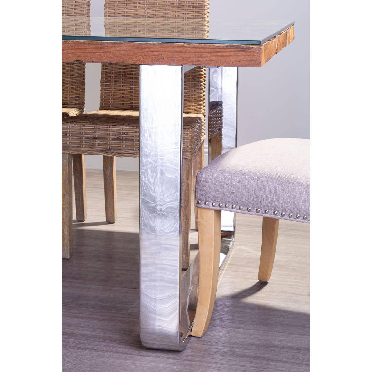 Glass top dining table with chrome legs and wicker chairs on wood floor