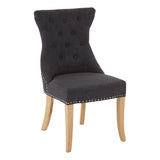 Charcoal upholstered dining chair with buttoned backrest and light wooden legs