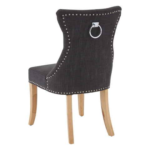 Black fabric dining chair with studded trim, chrome knocker back, and light wooden legs