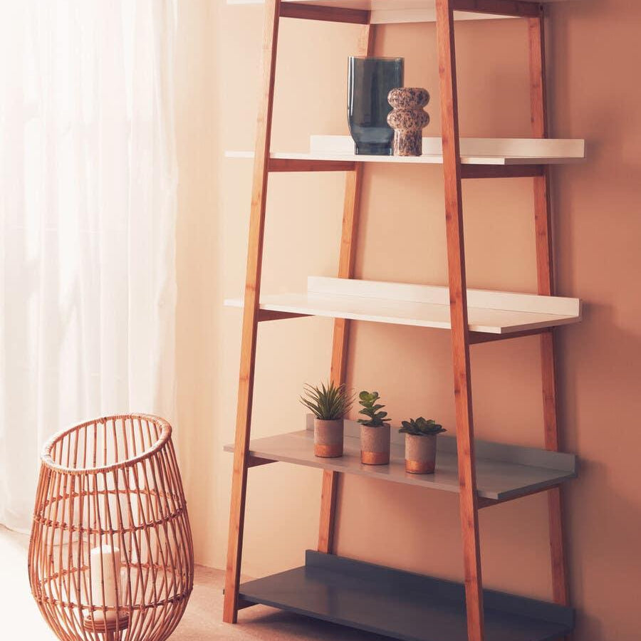 Wood shelving unit with white and grey shelves, decorated with vases and small plants