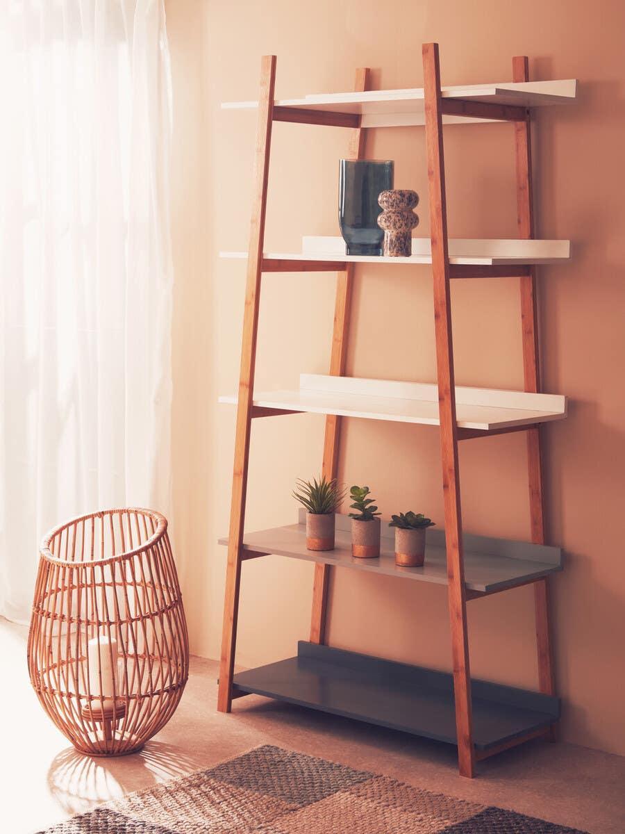 Wood shelving unit with white and grey shelves, decorated with vases and small plants