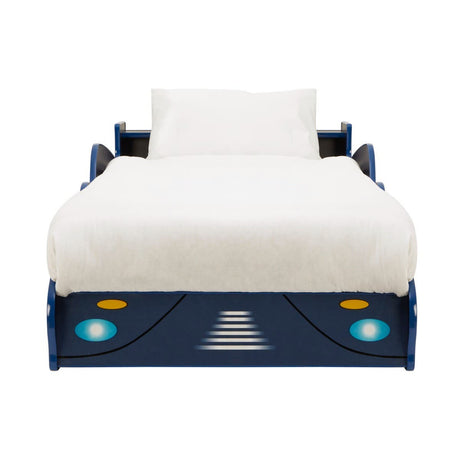 A blue kids racing car bed with a sleek design, featuring headlights and a streamlined front, topped with a white mattress and a simple white bedspread. The bed has side rails for safety and a playful, sporty aesthetic