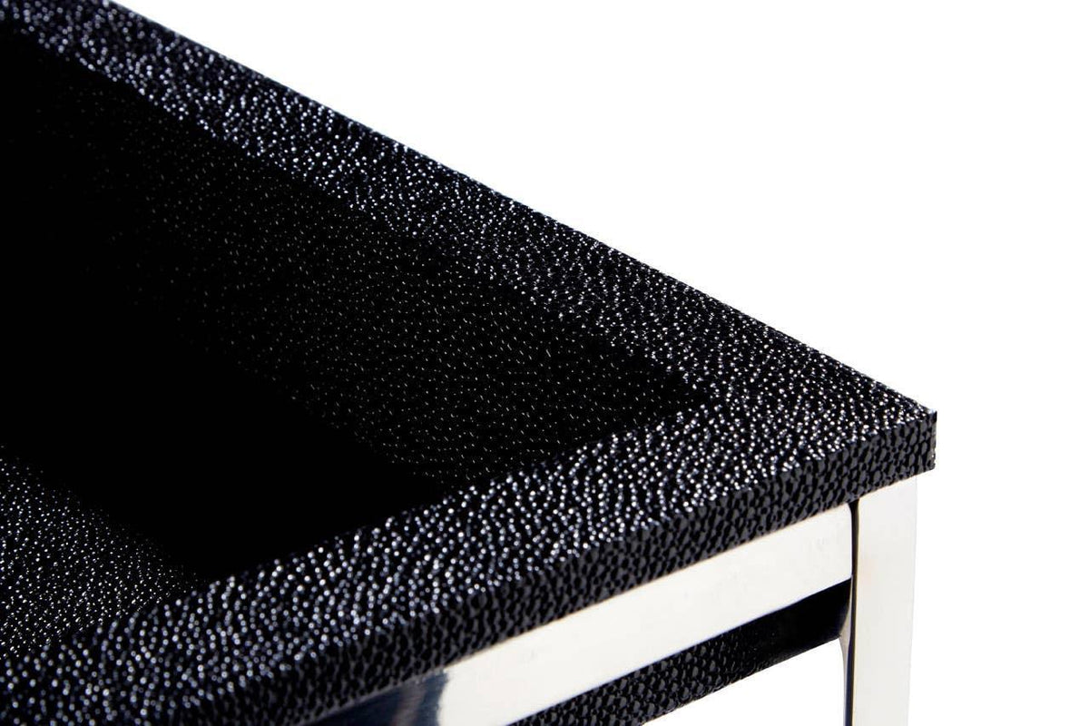 Closeup of black textured side table with chrome legs and modern finish
