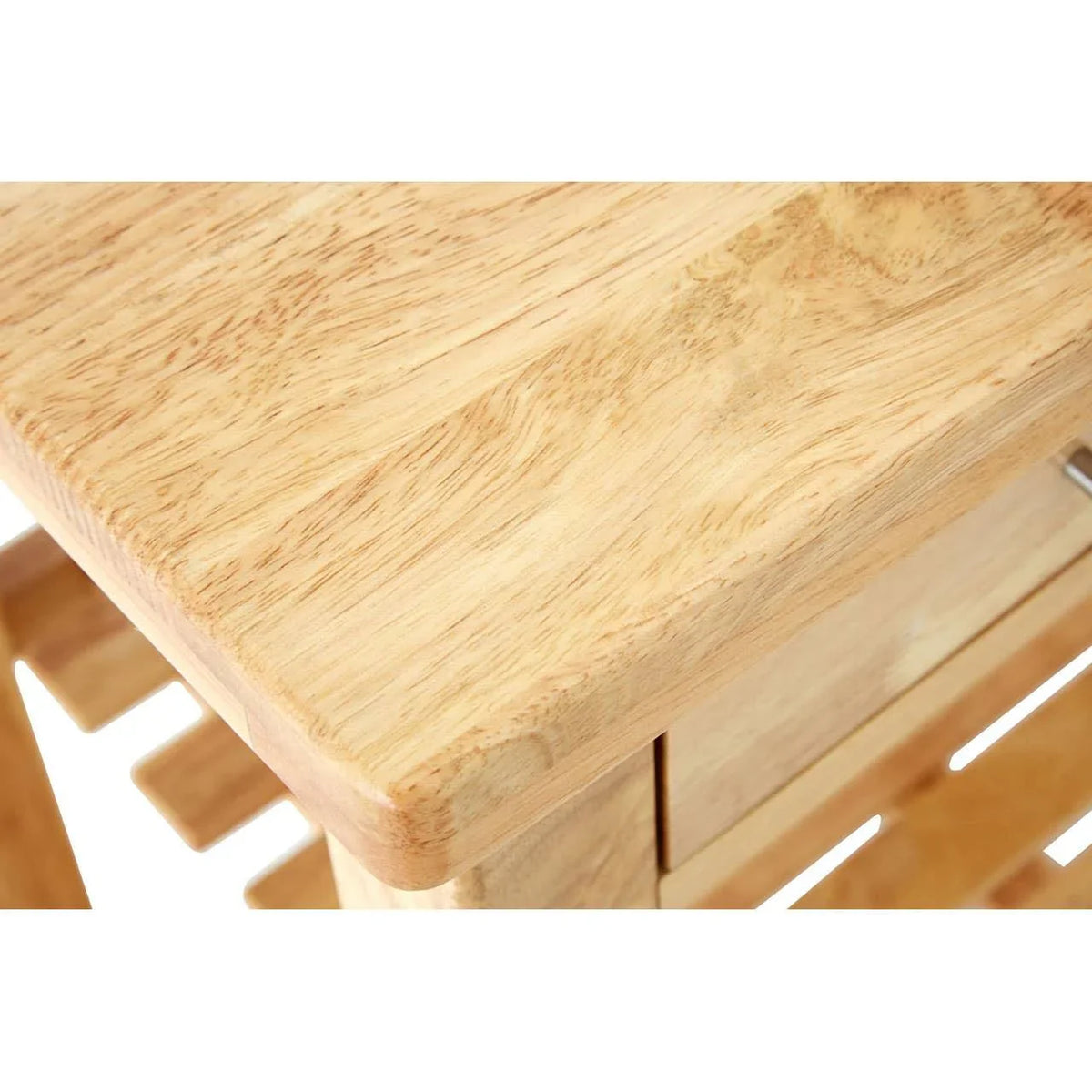 Close view of light wood dining table corner with smooth finish and visible wood grain