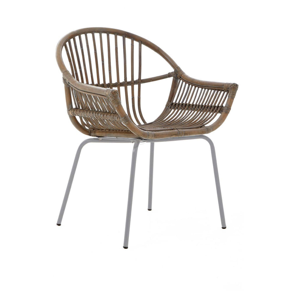 A stylish grey wash rattan chair featuring a curved backrest and open armrests, supported by sleek metal legs. The natural texture of the rattan adds a warm, organic feel to the design, making it suitable for various home decor styles
