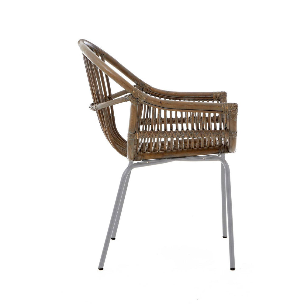 A side view of a Lagom grey wash natural rattan chair featuring a curved backrest and armrests, supported by sleek metal legs. The rattan weave showcases a natural texture, while the grey wash finish adds a modern touch
