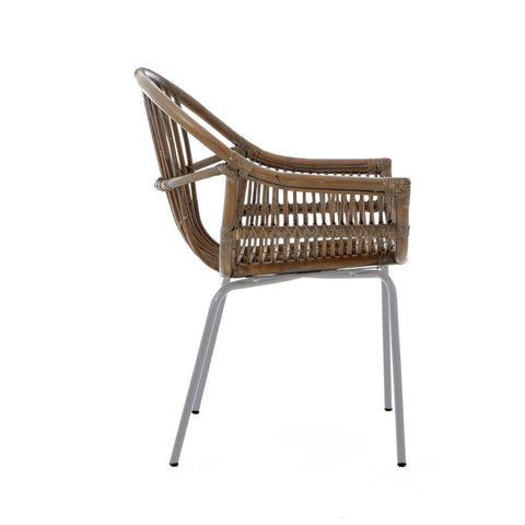 A side view of a Lagom grey wash natural rattan chair featuring a curved backrest and armrests, supported by sleek metal legs. The rattan weave showcases a natural texture, while the grey wash finish adds a modern touch
