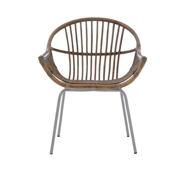 A grey wash natural rattan chair with a rounded backrest and slender vertical slats, supported by sleek metal legs. The chair features a comfortable, open design suitable for various home settings