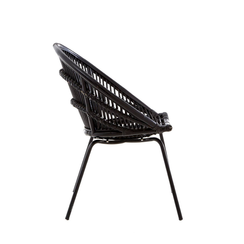 Side view of a black natural rattan chair featuring a woven seat and backrest supported by sleek iron legs. The chair has a modern design with a curved shape, showcasing the intricate rattan pattern