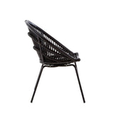 Side view of a black natural rattan chair featuring a woven seat and backrest supported by sleek iron legs. The chair has a modern design with a curved shape, showcasing the intricate rattan pattern