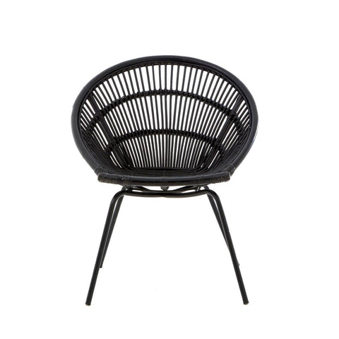 A round black rattan chair with a woven design and slender iron legs, showcasing a modern and minimalist style. The chair features a deep seat and an open back, emphasizing its airy and contemporary look