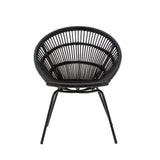 A round black rattan chair with a woven design and slender iron legs, showcasing a modern and minimalist style. The chair features a deep seat and an open back, emphasizing its airy and contemporary look