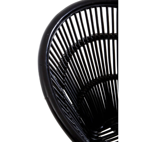 A close-up view of a black natural rattan chair featuring a curved backrest with vertical slats, showcasing the intricate weaving pattern. The chair is supported by sleek iron legs, emphasizing a modern and minimalist design