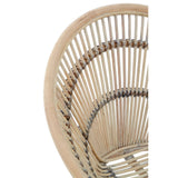 A close-up view of a white washed natural rattan chair, showcasing its curved backrest and intricate woven design, highlighting the light, airy aesthetic of the material
