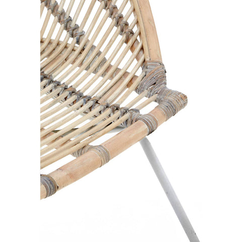 A close-up view of a white washed natural rattan chair, showcasing its woven seat and backrest with a light, airy design. The chair features a sleek metal frame with a minimalist aesthetic, highlighting the natural textures of the rattan