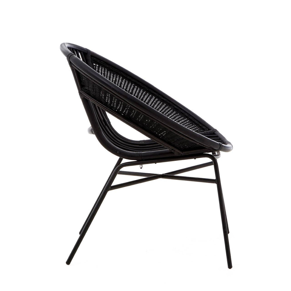 A side view of a black chair featuring a natural rattan seat and a sturdy iron frame, showcasing a modern design with a curved backrest and sleek legs