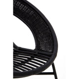 A close-up view of a black chair featuring a natural rattan seat and backrest, supported by a sleek black iron frame. The chair has a curved design with visible woven patterns in the rattan, showcasing its modern and stylish aesthetic