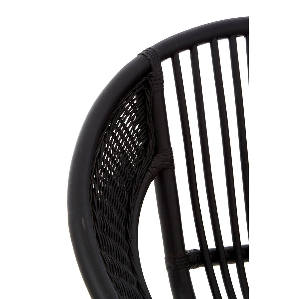 Close-up view of a black chair featuring a natural rattan seat and backrest, with sleek iron legs. The design showcases vertical slats in the backrest, emphasizing a modern and minimalist aesthetic