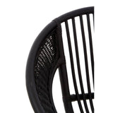Close-up view of a black chair featuring a natural rattan seat and backrest, with sleek iron legs. The design showcases vertical slats in the backrest, emphasizing a modern and minimalist aesthetic