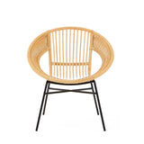 Natural rattan chair with a rounded backrest and black iron legs, showcasing a minimalist design that combines organic textures with modern materials. The chair features vertical slats in the back and a wide seat, emphasizing comfort and style