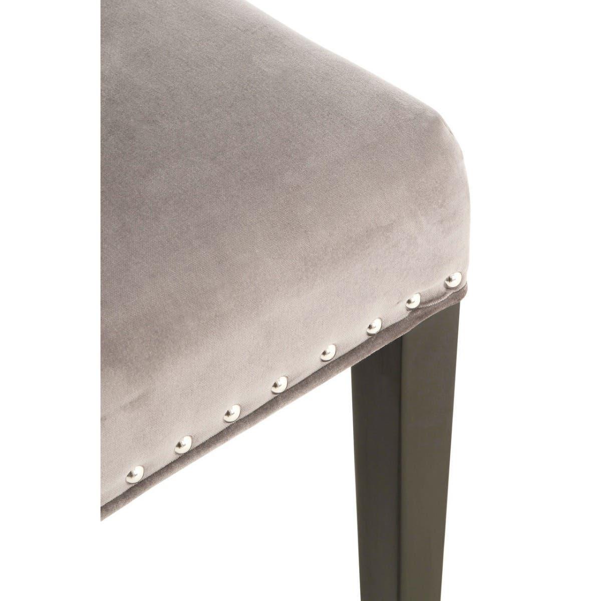 Grey velvet dining chair seat with silver stud trim and black wooden leg close-up