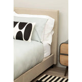 Beige upholstered bed frame with pale bedding beside modern wooden bedside table