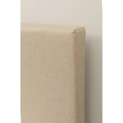 Beige upholstered headboard corner with fabric texture against light wall