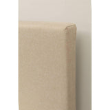 Beige upholstered headboard corner with fabric texture against light wall