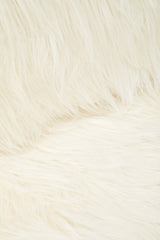 Soft white faux fur upholstery with a plush texture, showcasing a close-up view of the fabric. The fibers appear fluffy and inviting, highlighting the luxurious feel