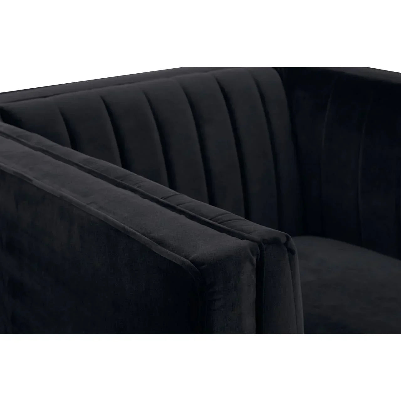 Close up of black velvet sofa with vertical channel tufted back and arm detail