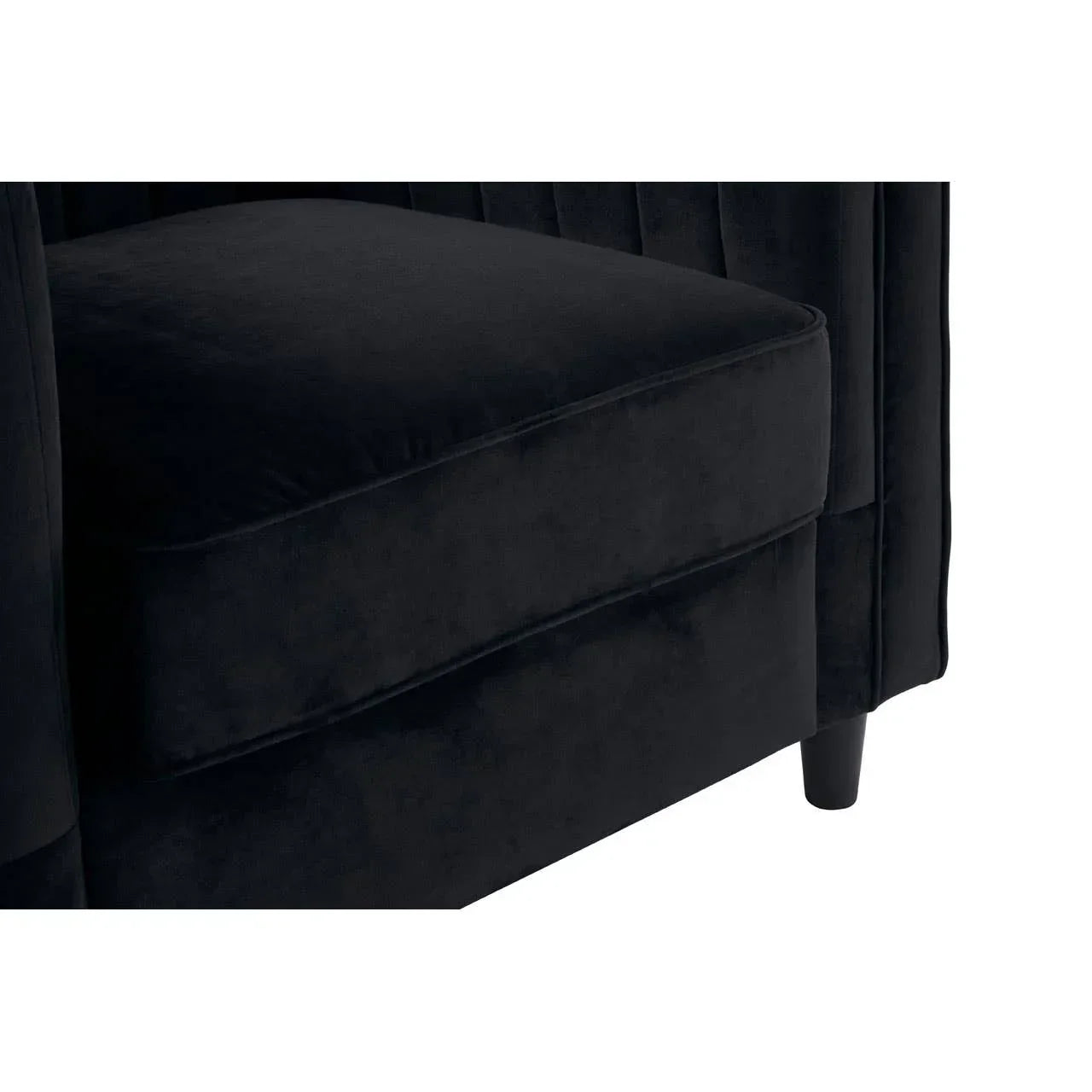 Close up of black velvet sofa seat with stitched detail and wooden leg