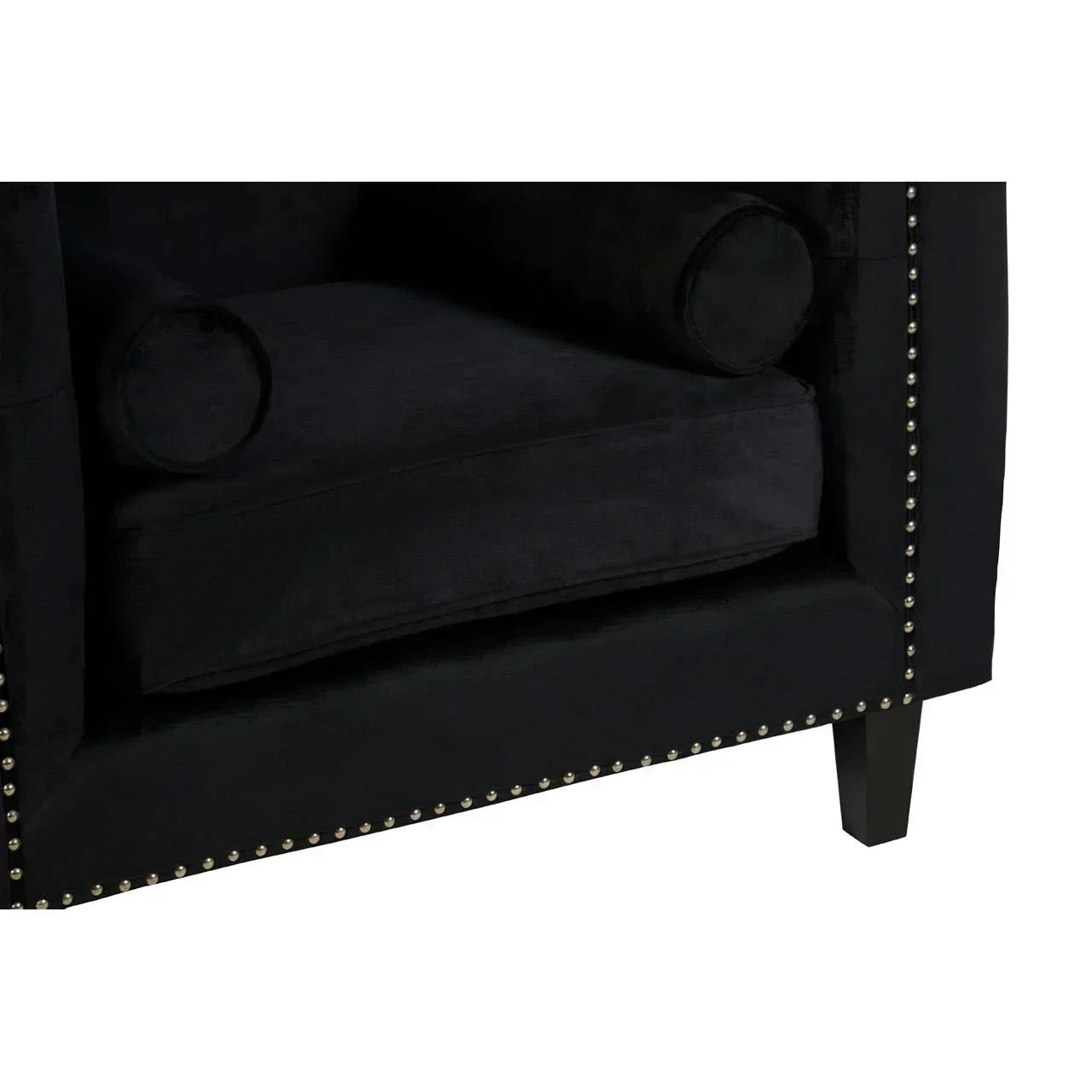 Black velvet armchair with silver stud detailing and bolster cushions, corner view